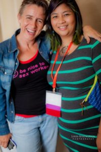 Two Sex Geek Salon 2016 attendees smiling for the camera. One is wearing a shirt that says "Be nice to sex workers"