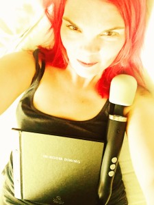 JoEllen taking a selfie holding a Doxy wand and a room service menu