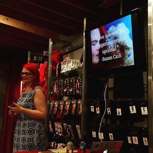 JoEllen teaching in front of a screen featuring a picture of her dog kissing her