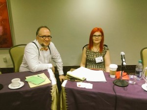 Man and woman sitting behind microphones