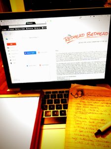 A laptop computer with a tablet and a notebook open on top of it