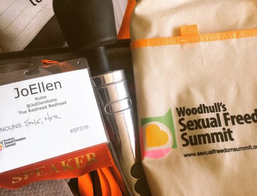 Silver Doxy Die Cast wand, JoEllen's name badge, and a bag from Woodhull's Sexual Freedom Summit