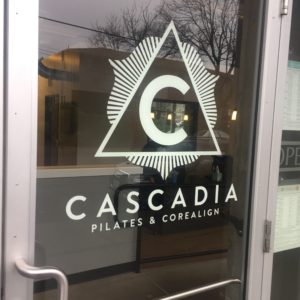 Glass door reading "Cascadia Pilates & Corealign"